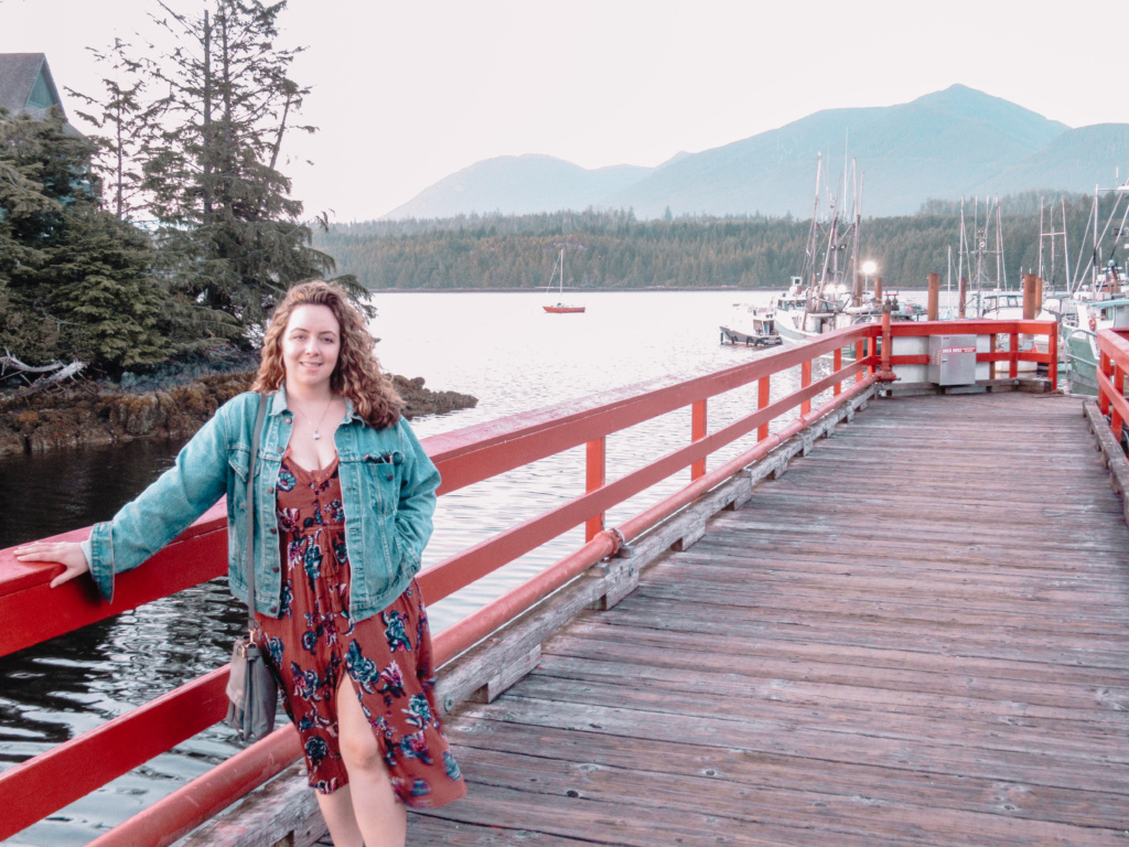 A woman stands on the warf of Ucluelet Habour. 