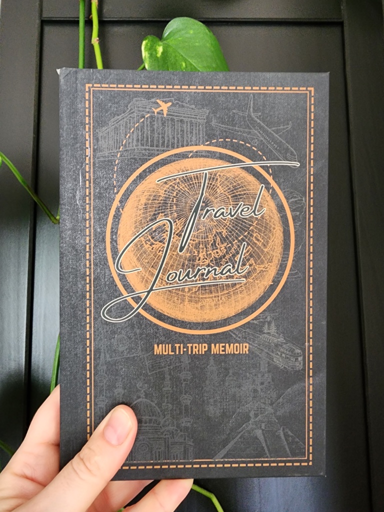 Travel Journal Held up by Hand